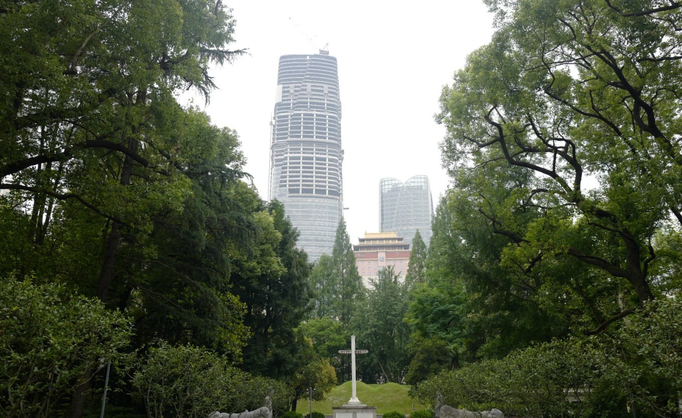 Distant view of Xu Guangqi's tomb with stone statues and a visible cross