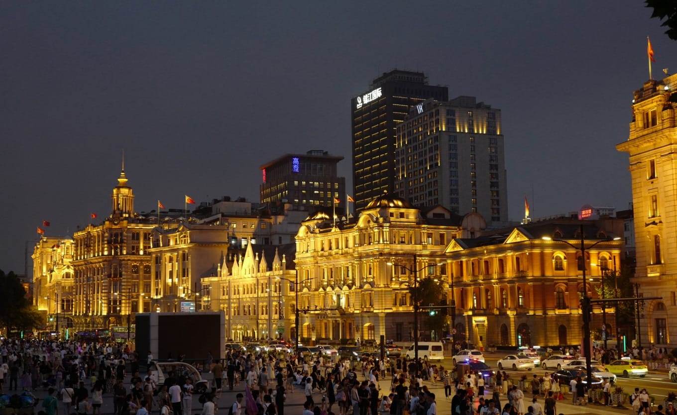 A bustling modern shopping street in Shanghai with colorful signage and crowds