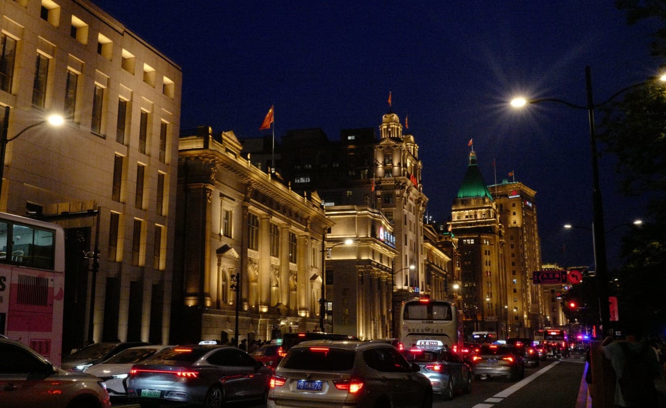 Night photography setup showing tourist crowds and buses along The Bund