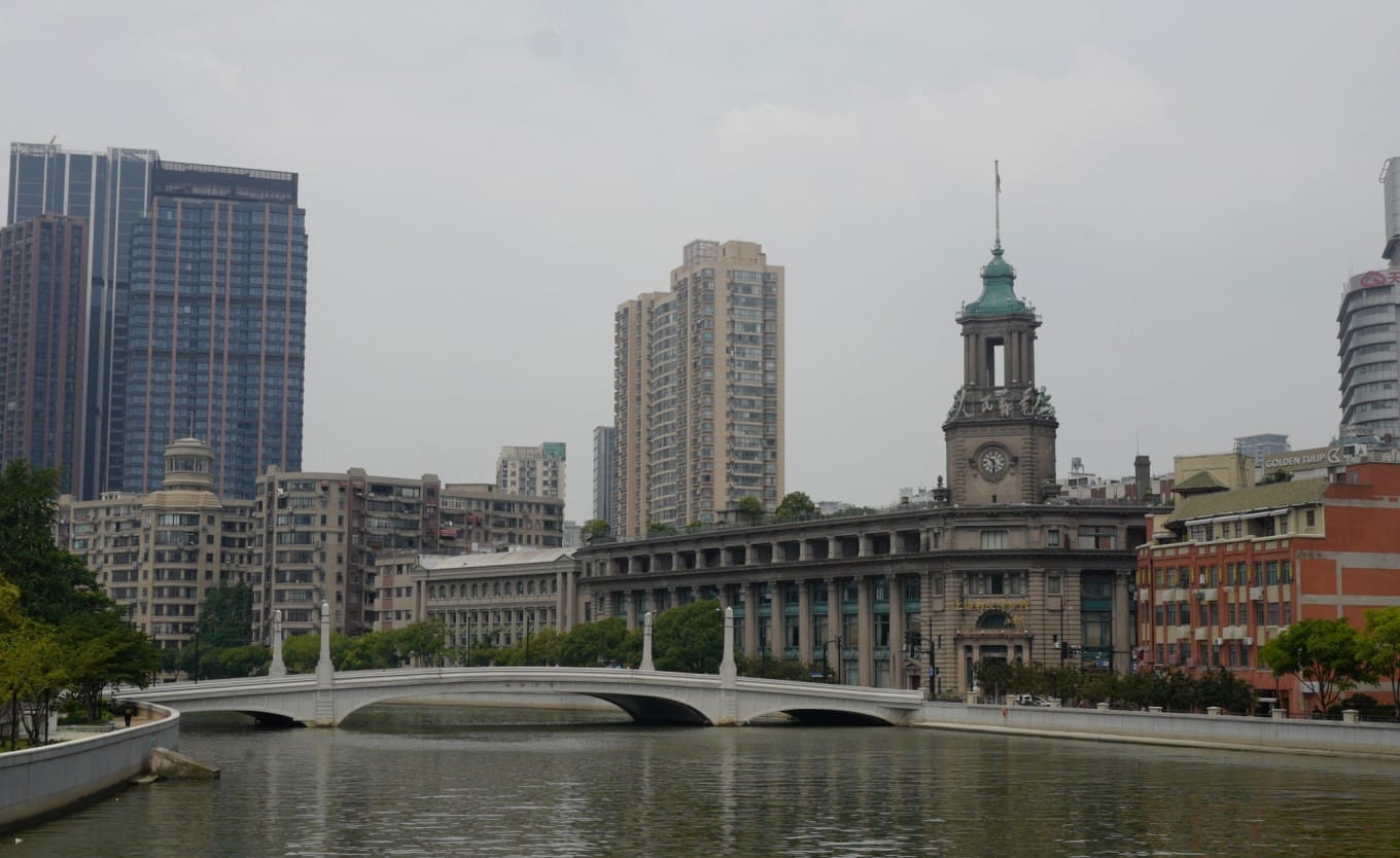 Sichuan Road Bridge spanning Suzhou Creek with historic buildings in background