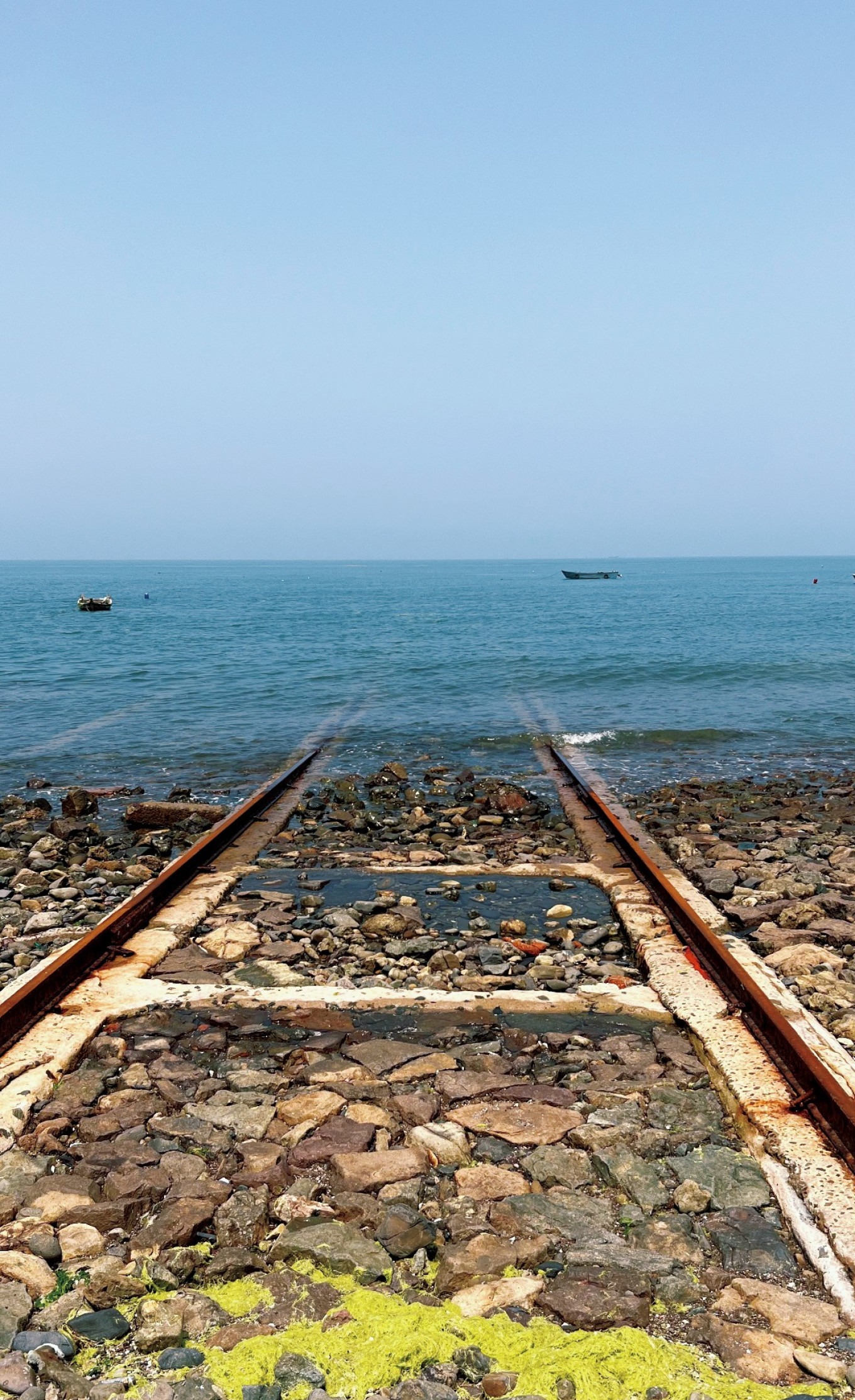 Railway track disappearing into the sea