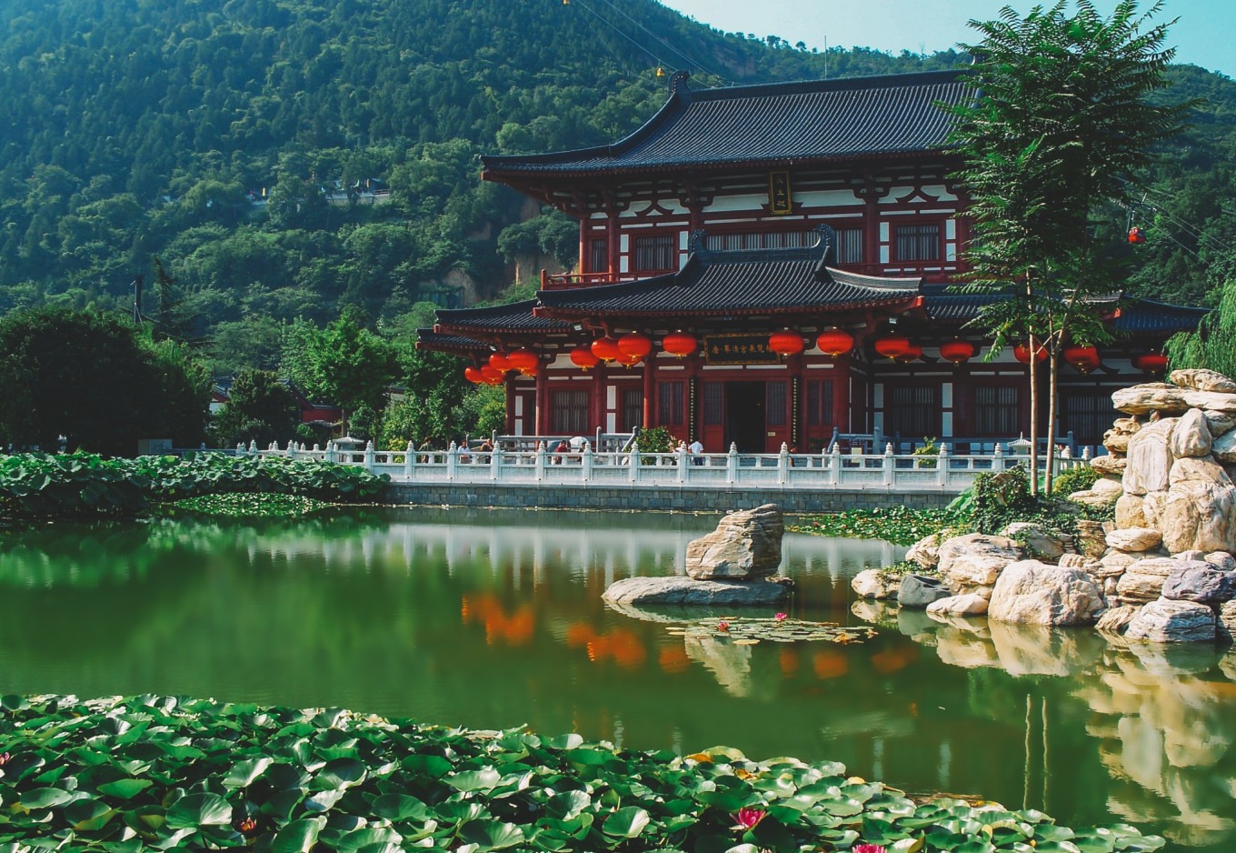 Ornate palace buildings surrounding Huaqing Pool with mountains in background