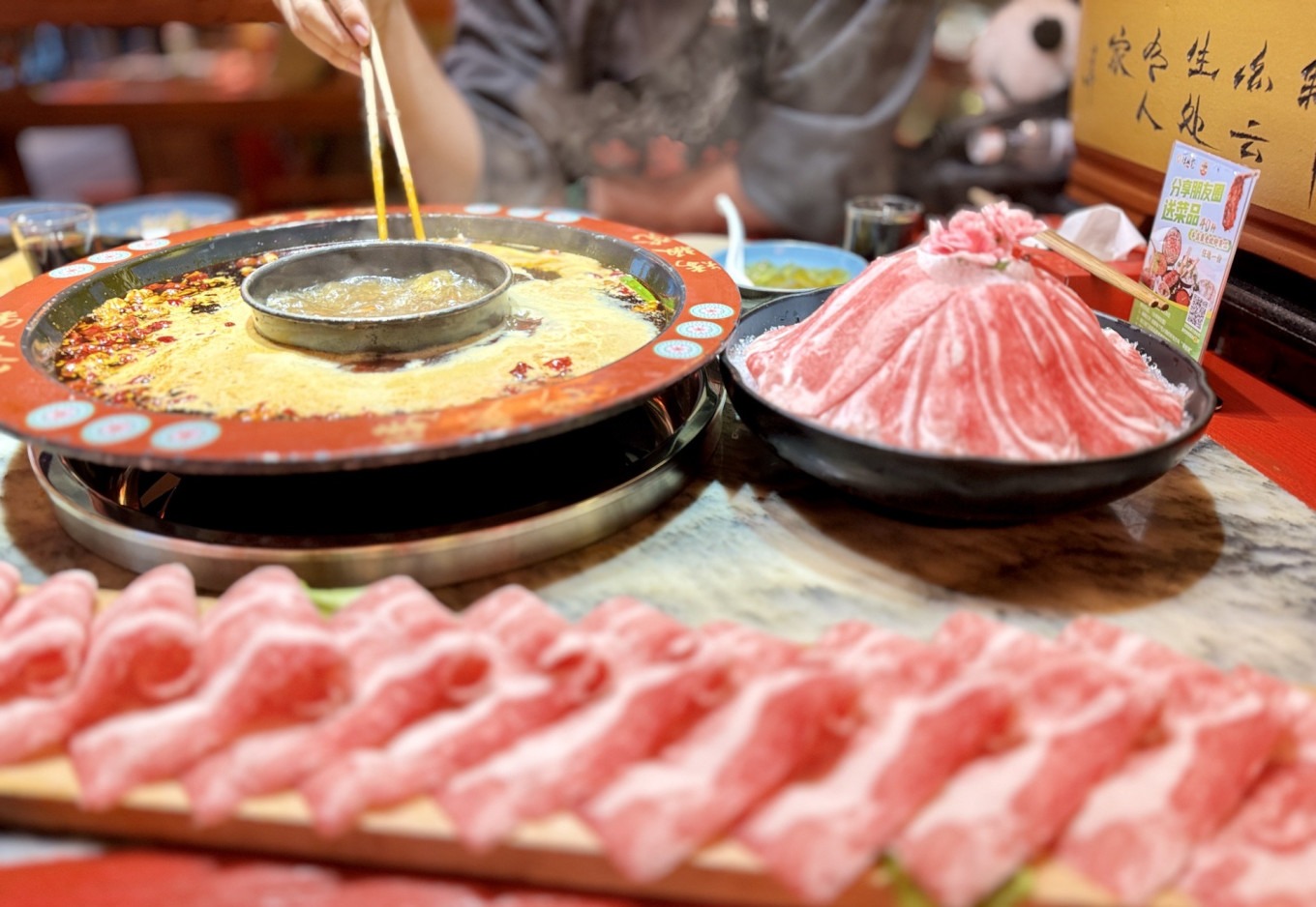 Hotpot bubbling in a pot with ingredients on the table