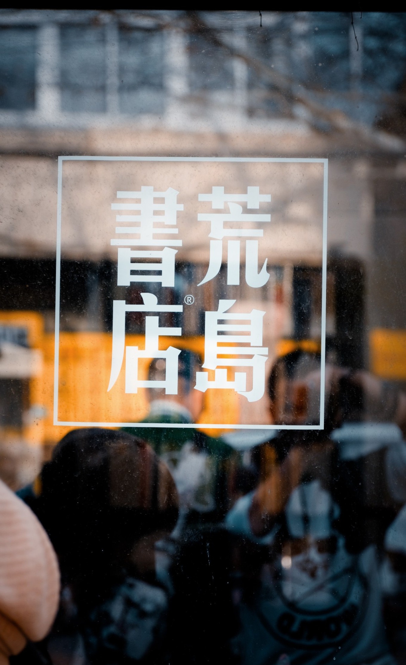 A red wall with white street sign at the intersection of Yushan Road and University Road in Qingdao