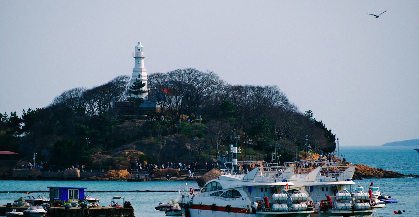 Sunset view over Xiaomai Island with crowds silhouetted against golden sky