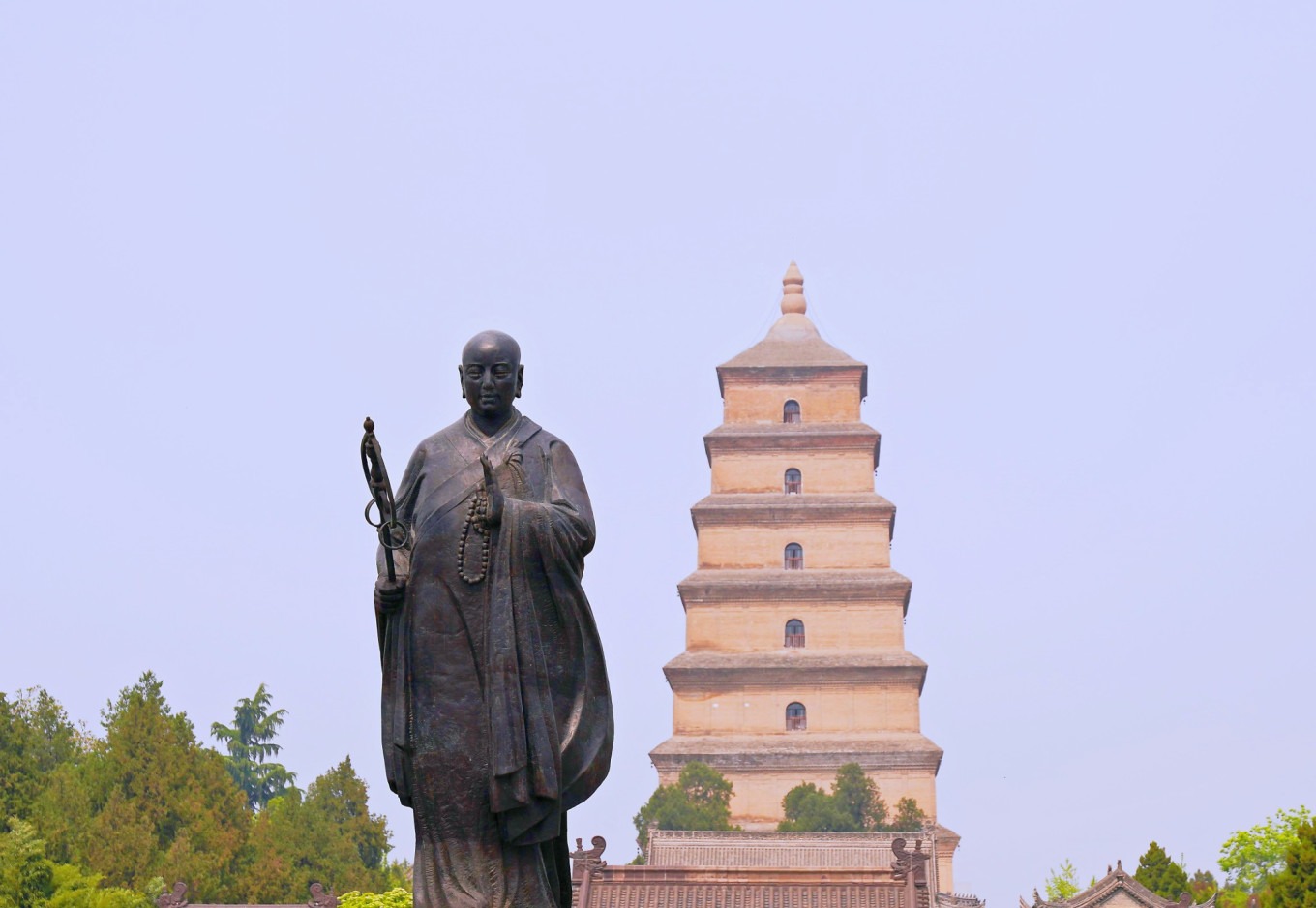 Close-up of Xuanzang statue with pagoda behind at south square