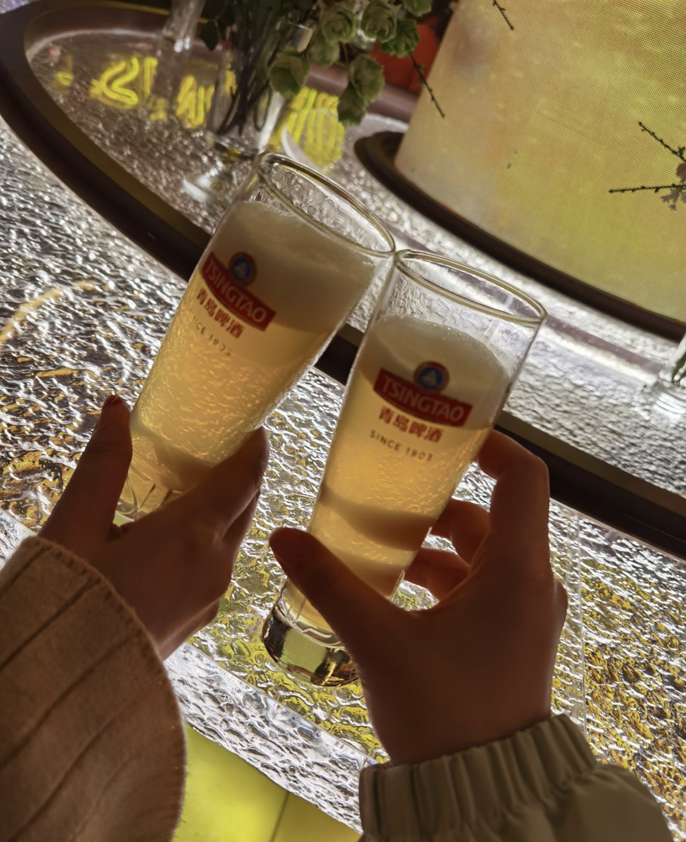 Visitors holding beer glasses at the museum bar