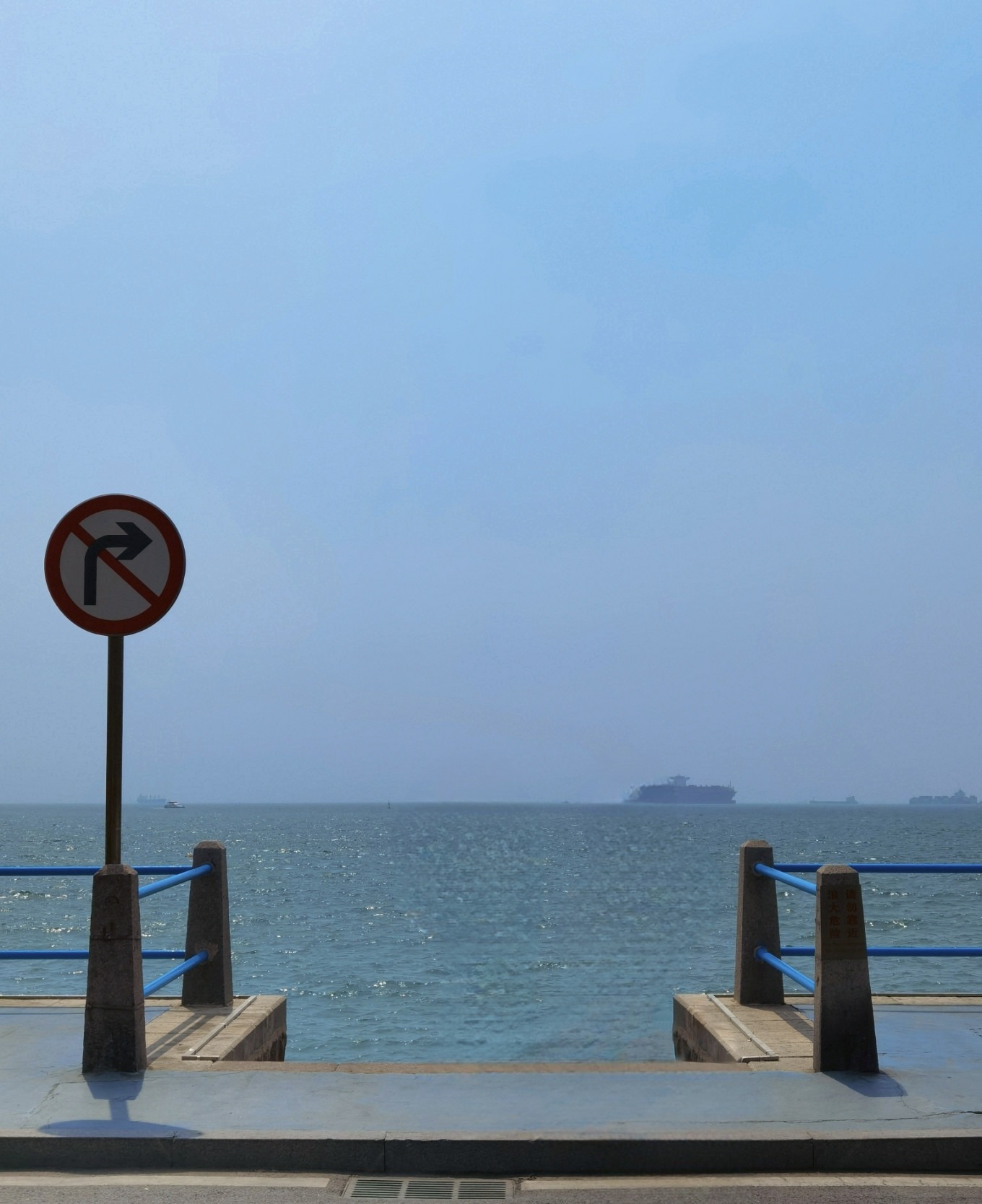 View at Xilingxia One Road with a no-right-turn sign and the sea at the end of the road
