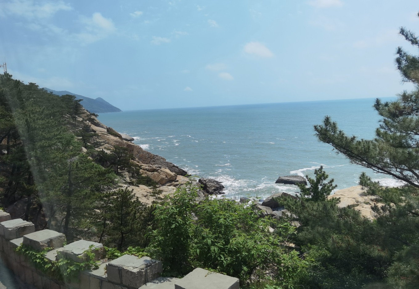 Shuttle bus window view of the sea and mountains
