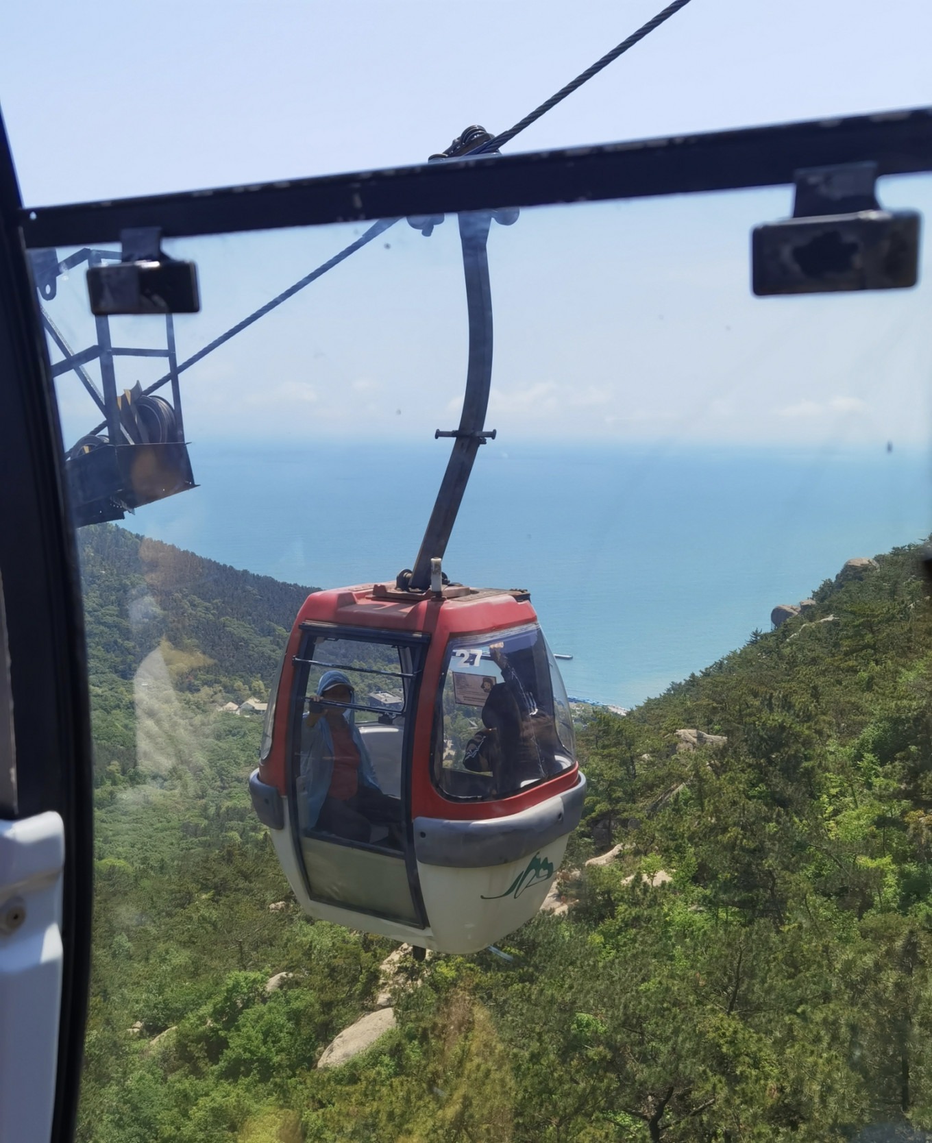 Cable car ascending over forested mountains