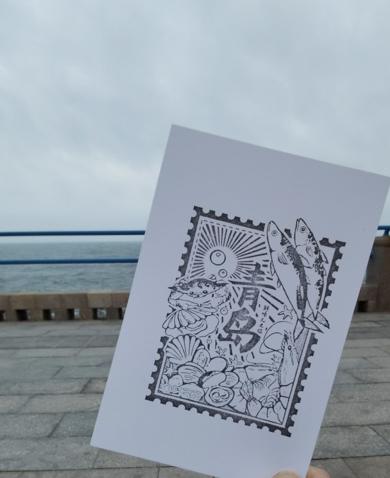 Close-up of a stamp with a lighthouse and sea motif