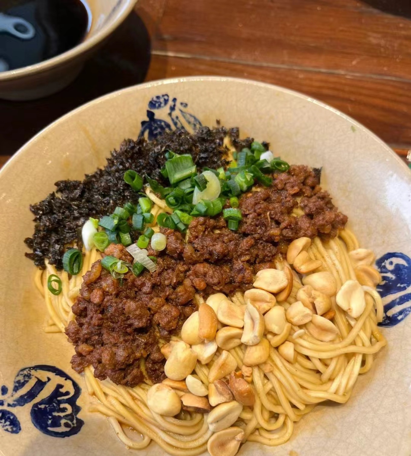 Bowl of Dan Dan Mian (noodles) with minced pork and peanuts