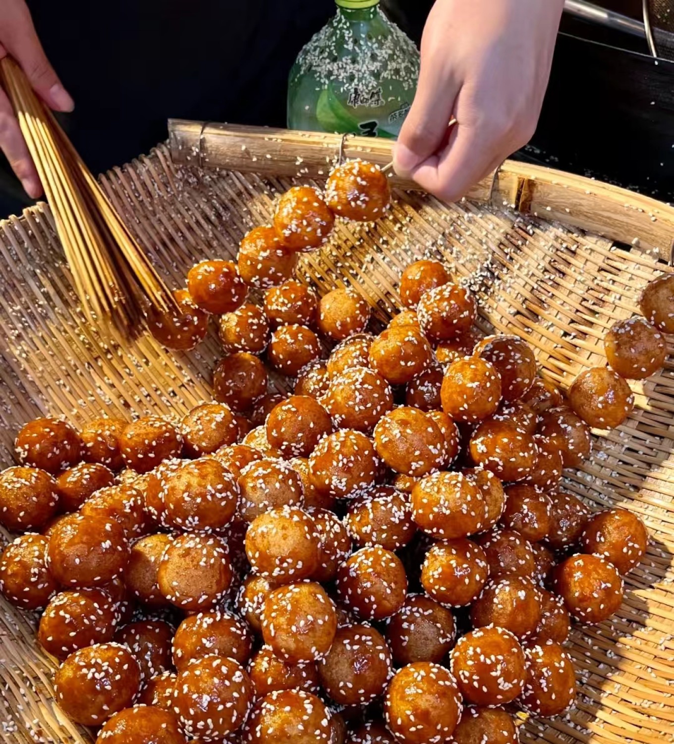 Glutinous rice balls on skewers coated in caramelized sugar and sesame