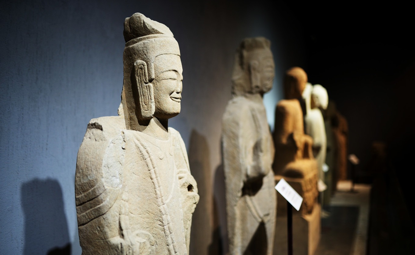 Display of multiple stone Buddha statues in a row