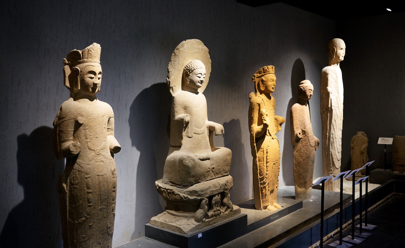 Single standing Buddha statue with flowing robes