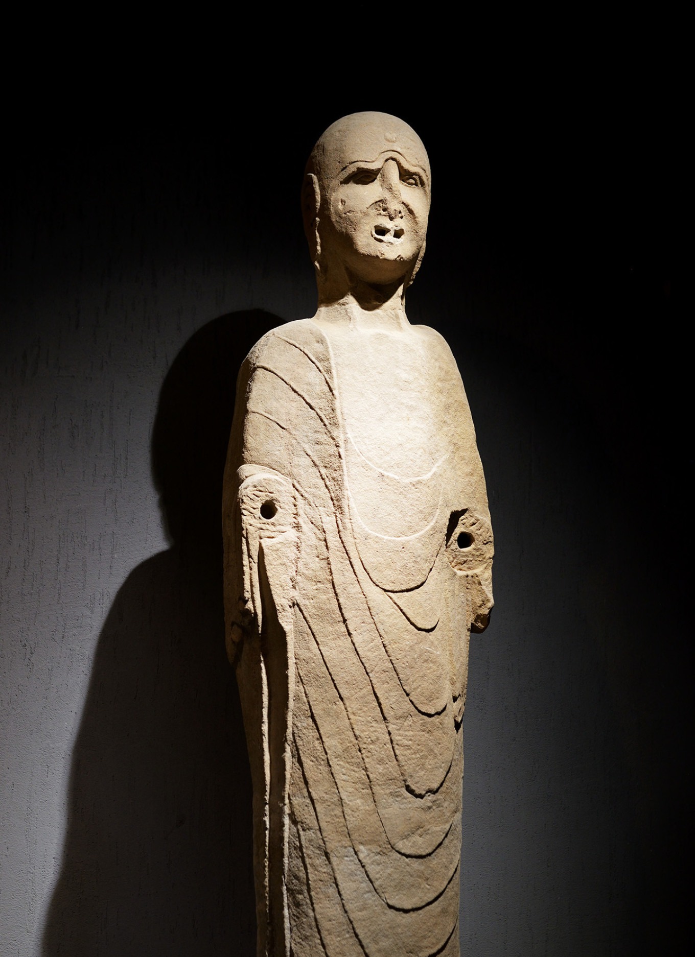 Tall statue of Mahakashyapa with wrinkled face and detailed robes