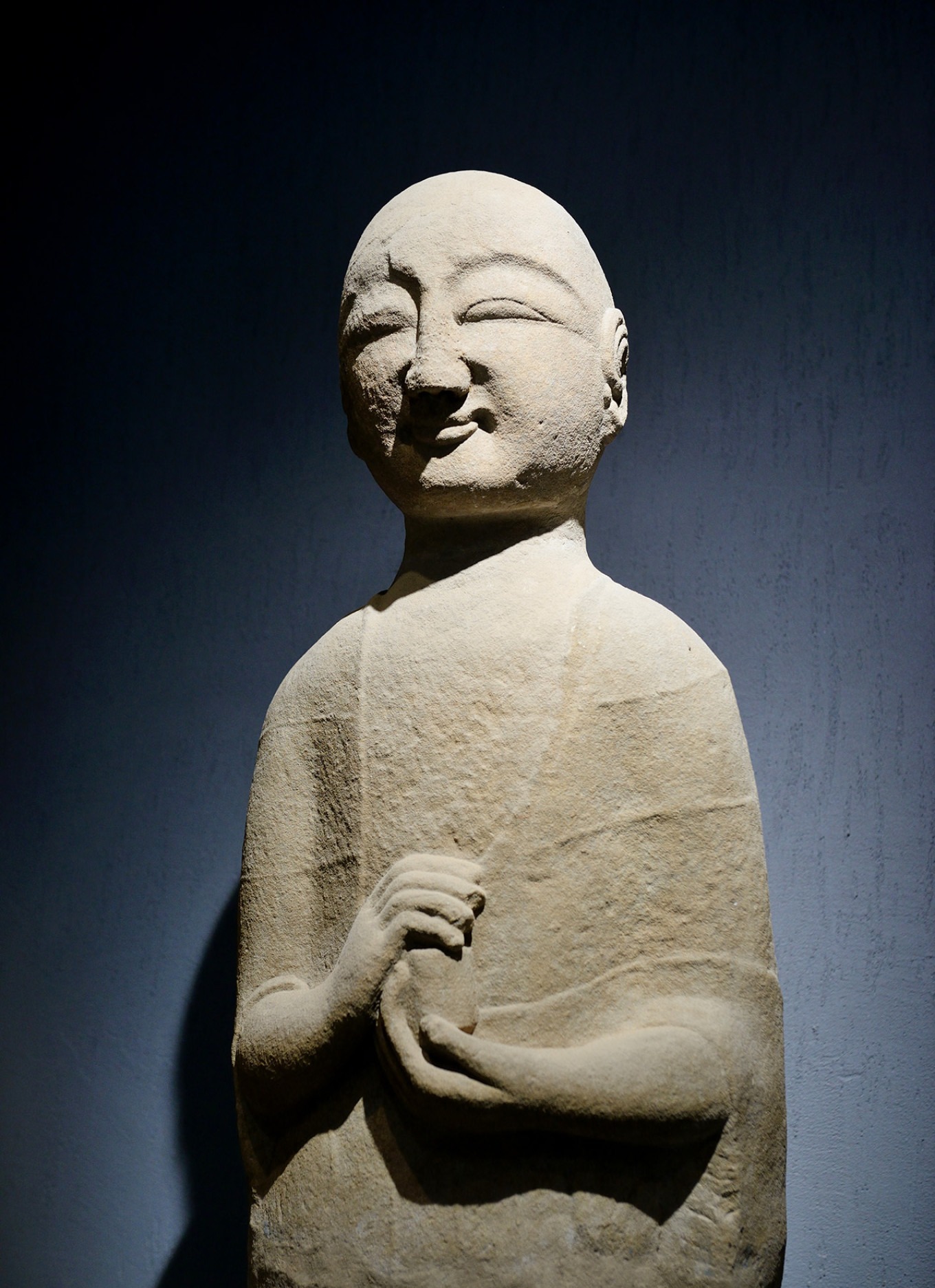 Statue of Ananda with a youthful face and hands holding a pearl