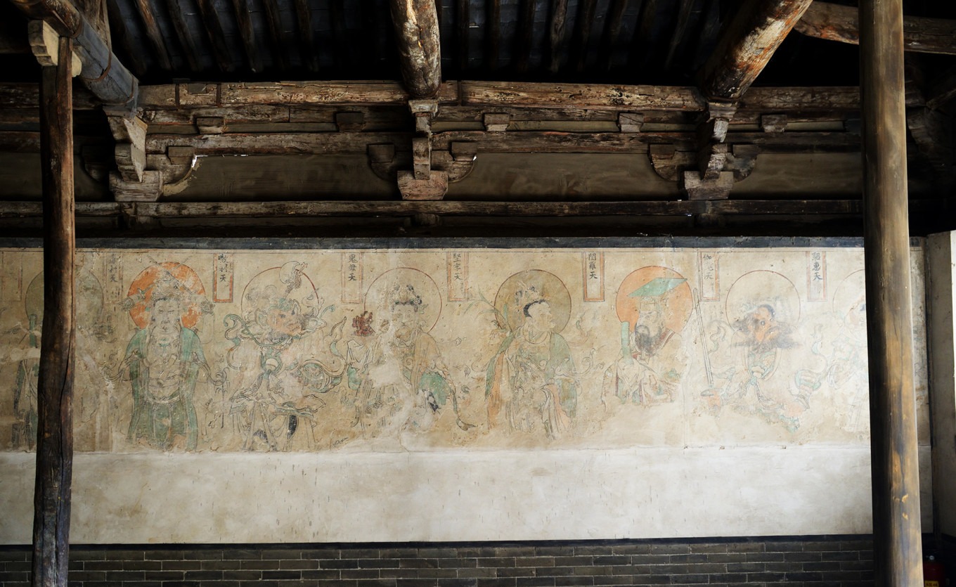Detail of the mural with green and red tones and gold highlights