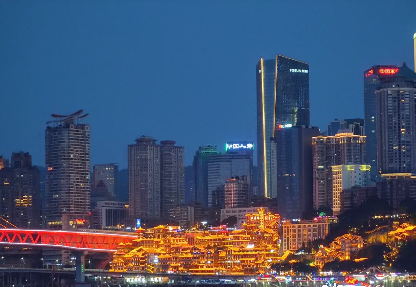 Hongya Cave lit up at night with golden stilted buildings
