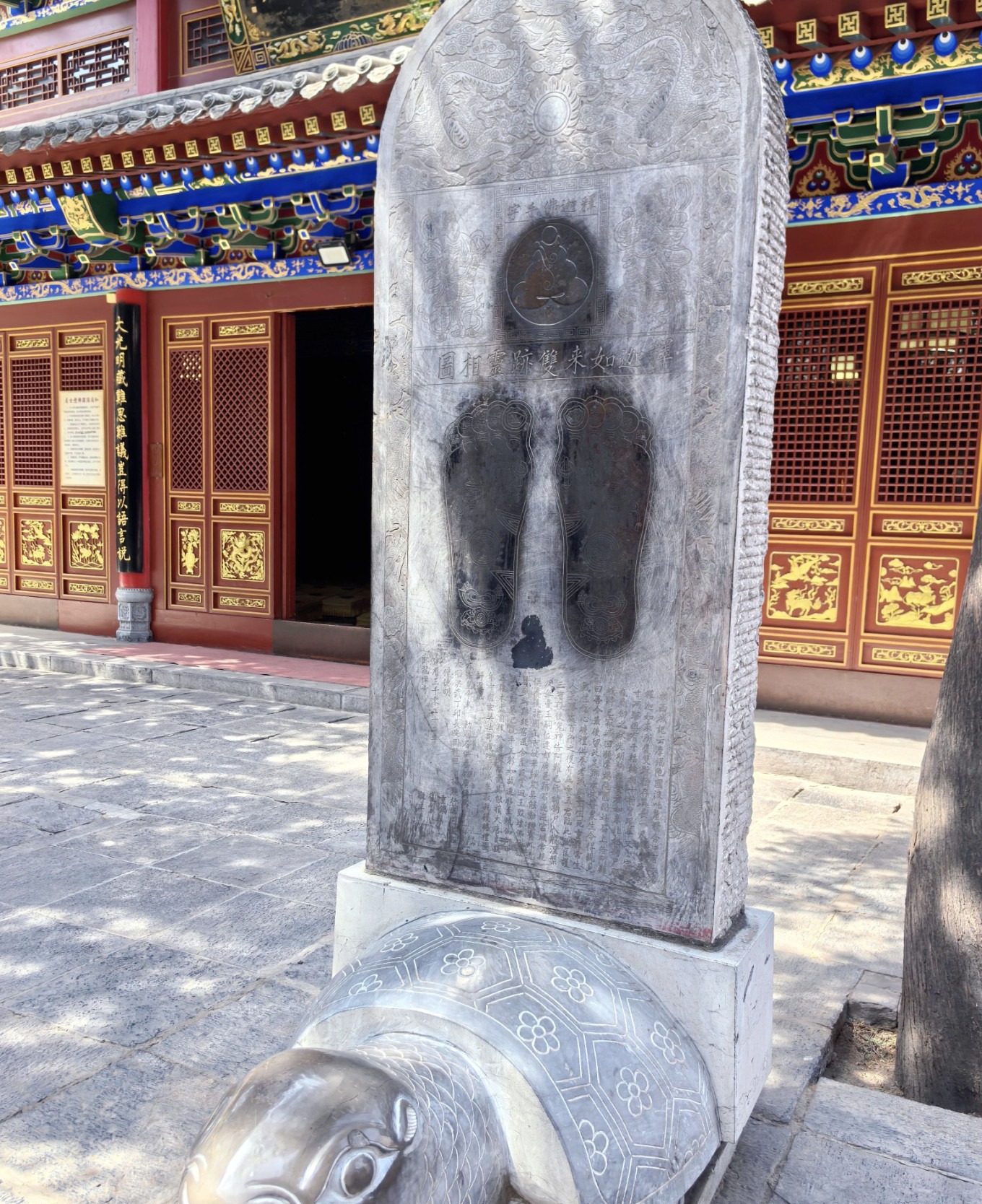 Close-up of a smooth stone surface rubbed by visitors at Wolong Temple