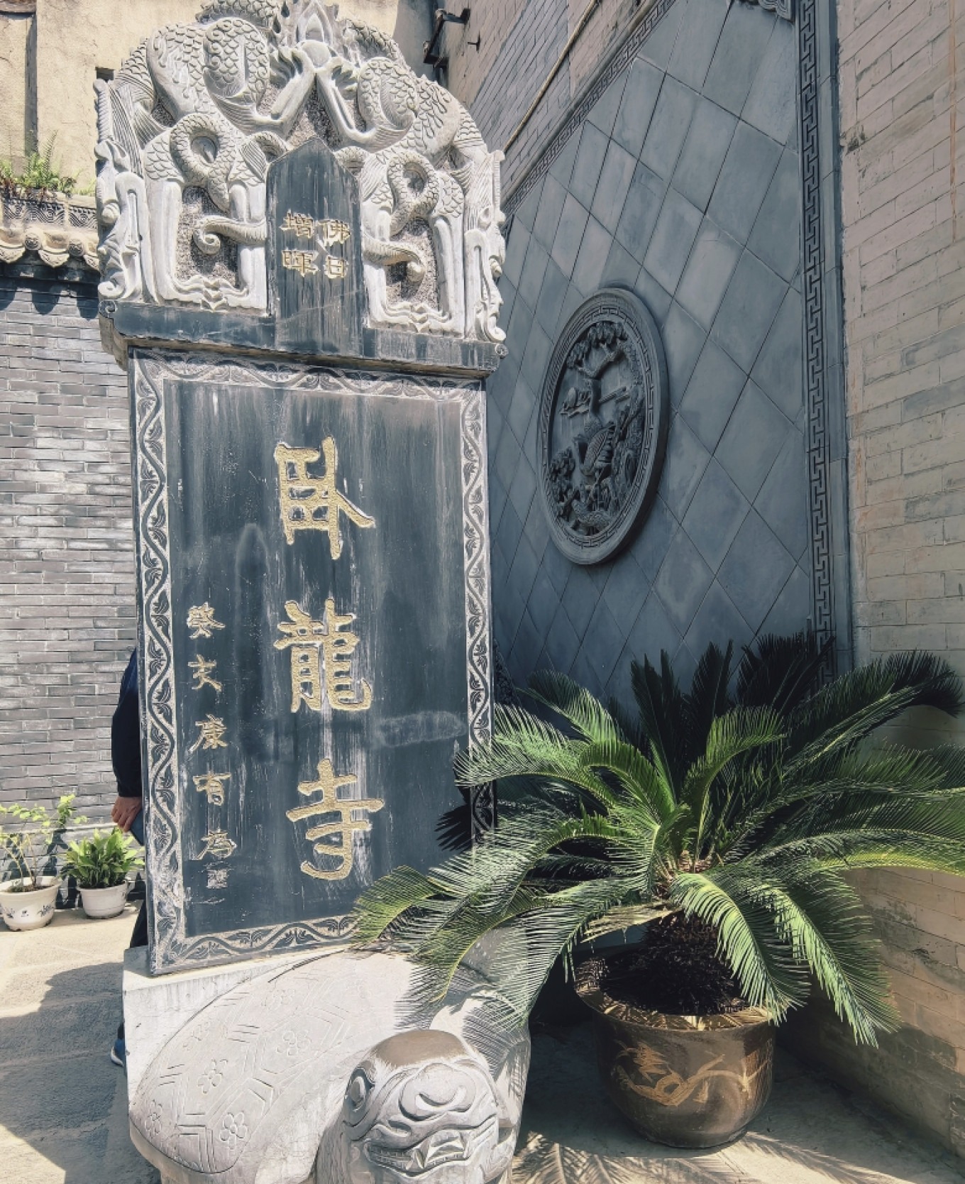 Ancient bronze bell and stone tablets inside Crouching Dragon Temple