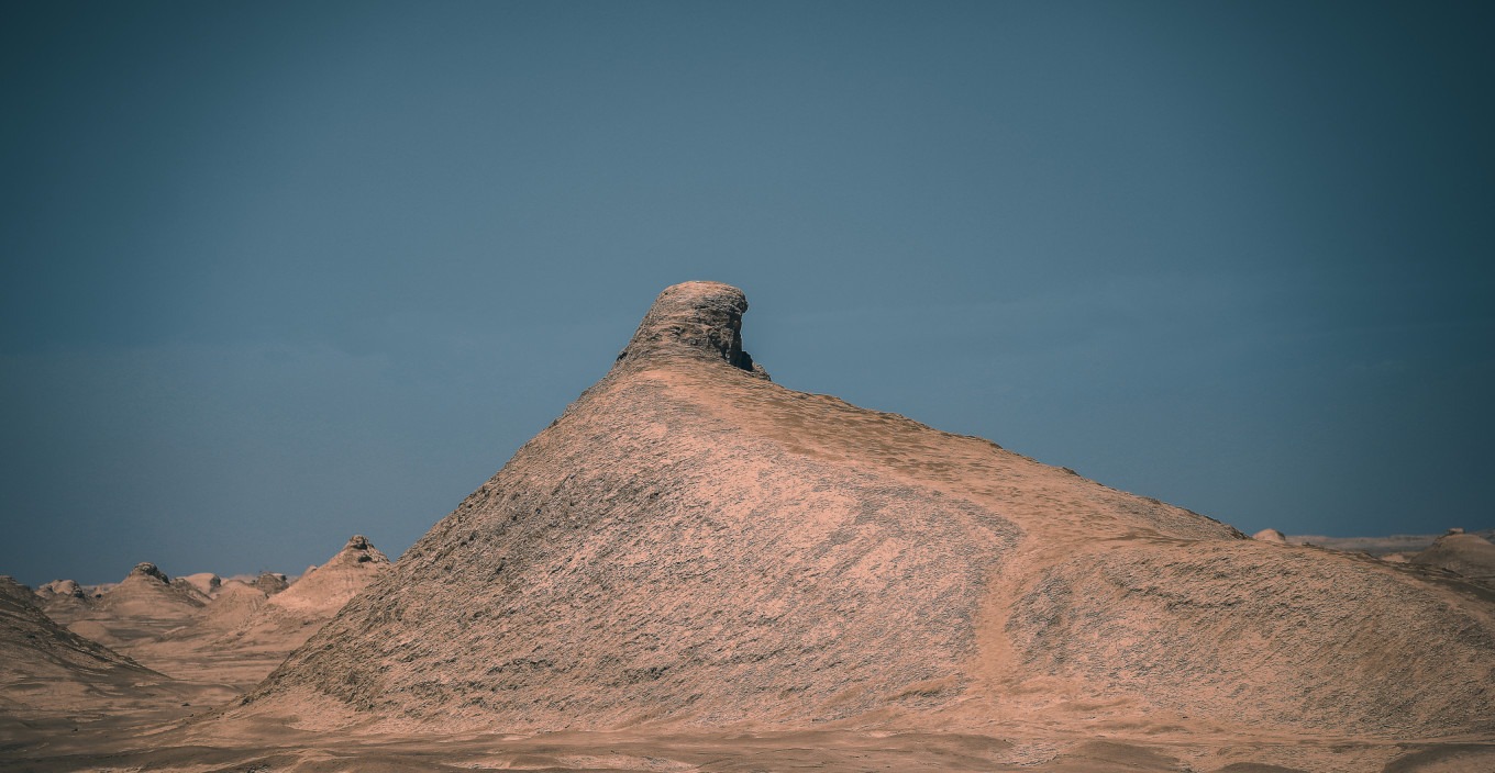 Low-angle shot of a tall Yadan mound against blue sky