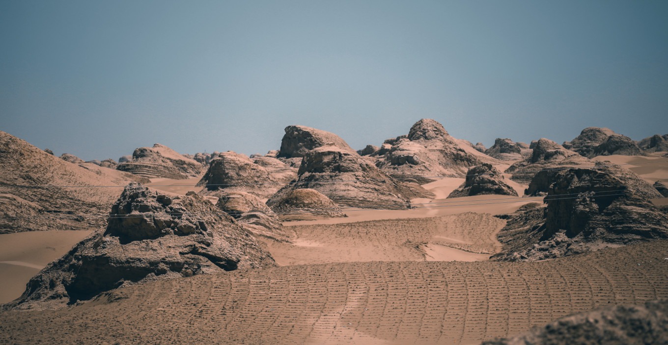 The U-shaped highway dipping into the desert with trucks