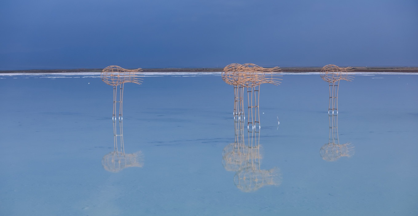 Person walking on the salt lake with reflection