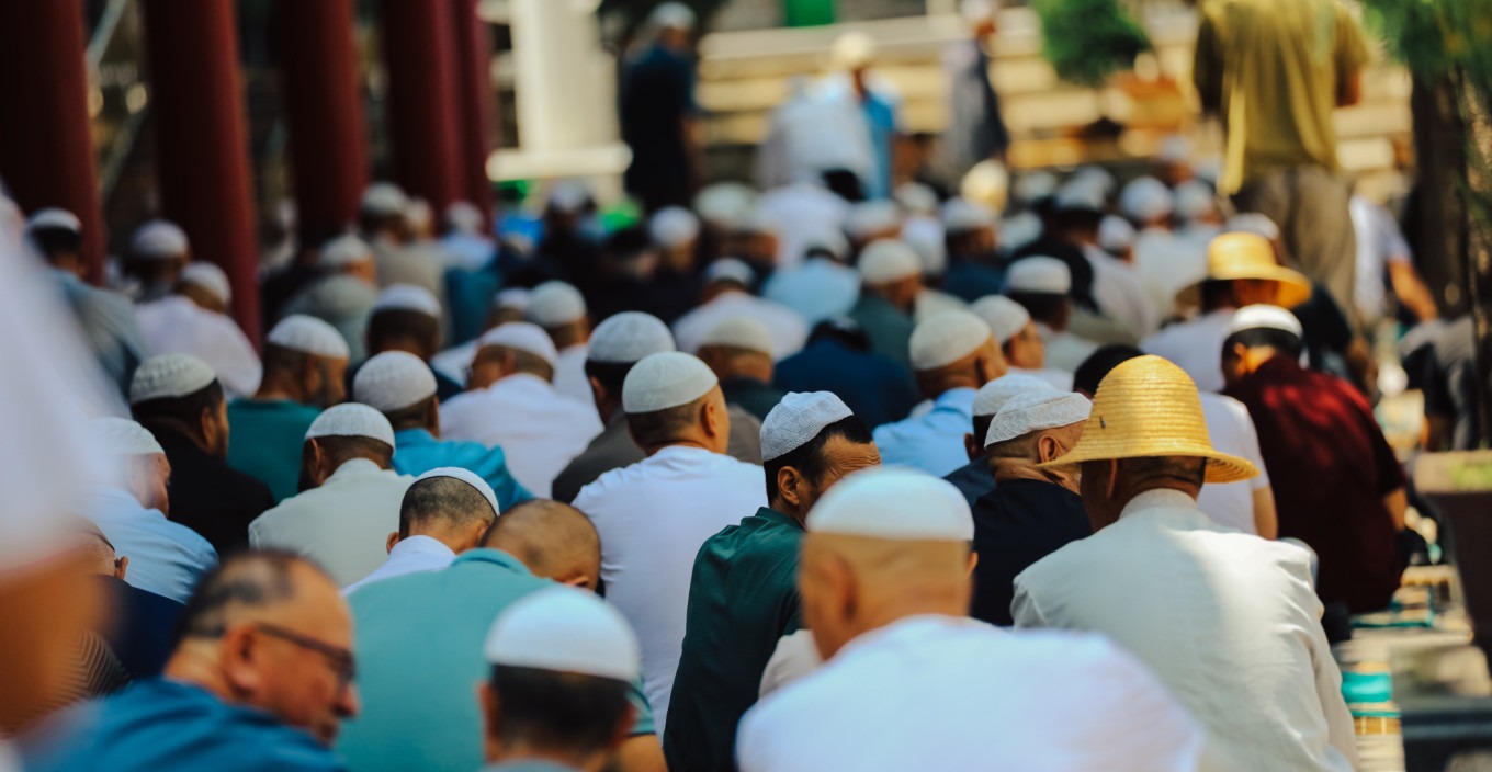 Rows of worshippers kneeling in prayer in the square