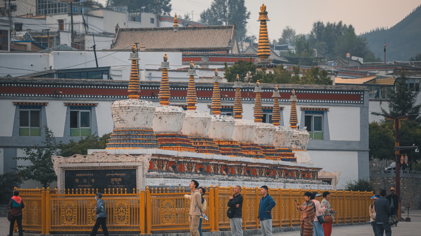 Row of eight white stupas with blue sky