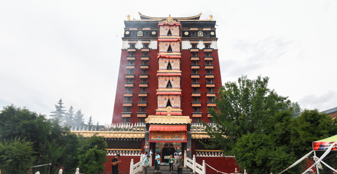 Ornate ceiling and thangka inside a monastery hall