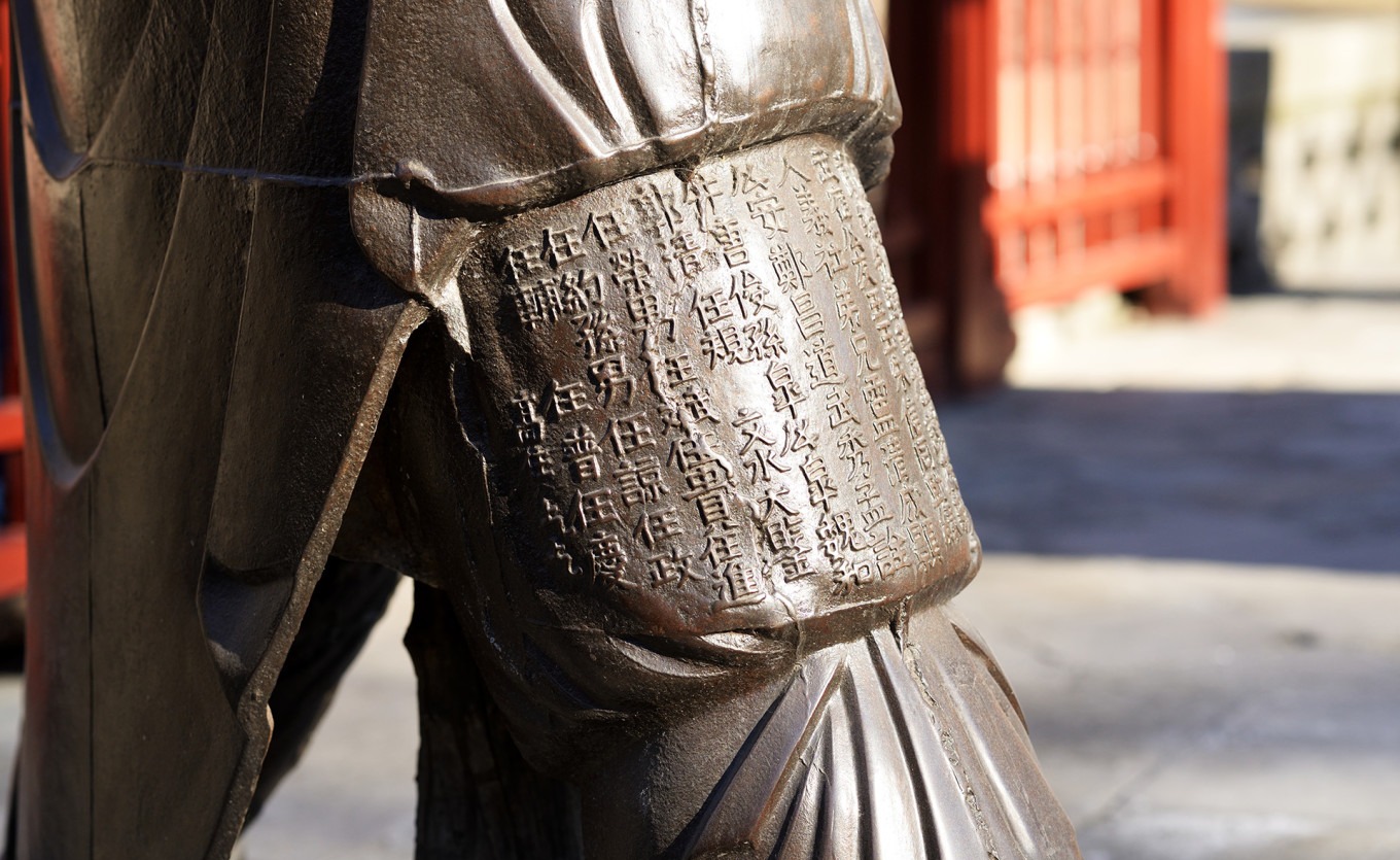 Close-up of inscriptions on iron figure's leg
